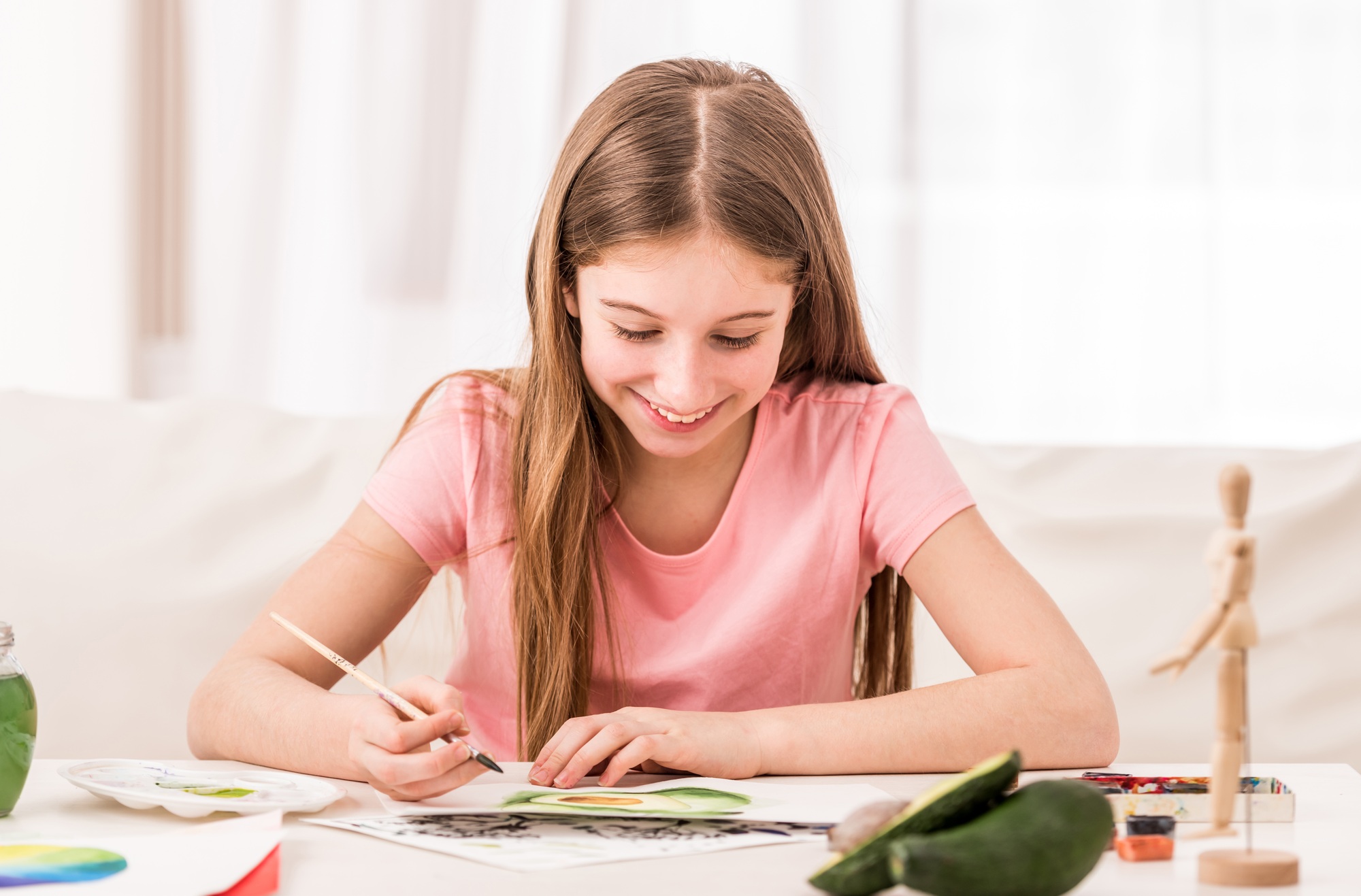 Girl smiles when drawing green avocado