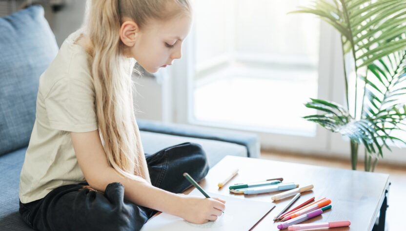Child girl drawing with colorful pencils