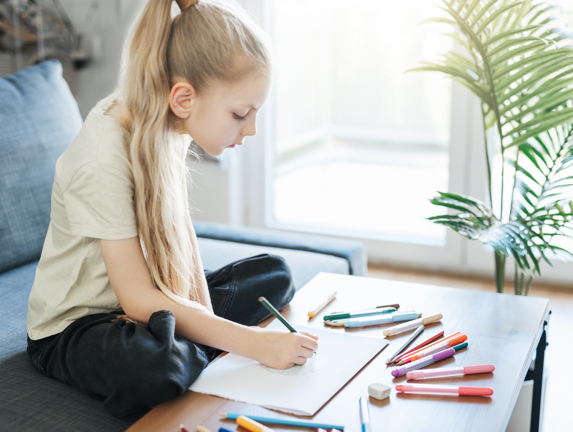 Child girl drawing with colorful pencils