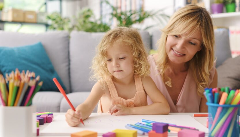 Girl and mother drawing together at home