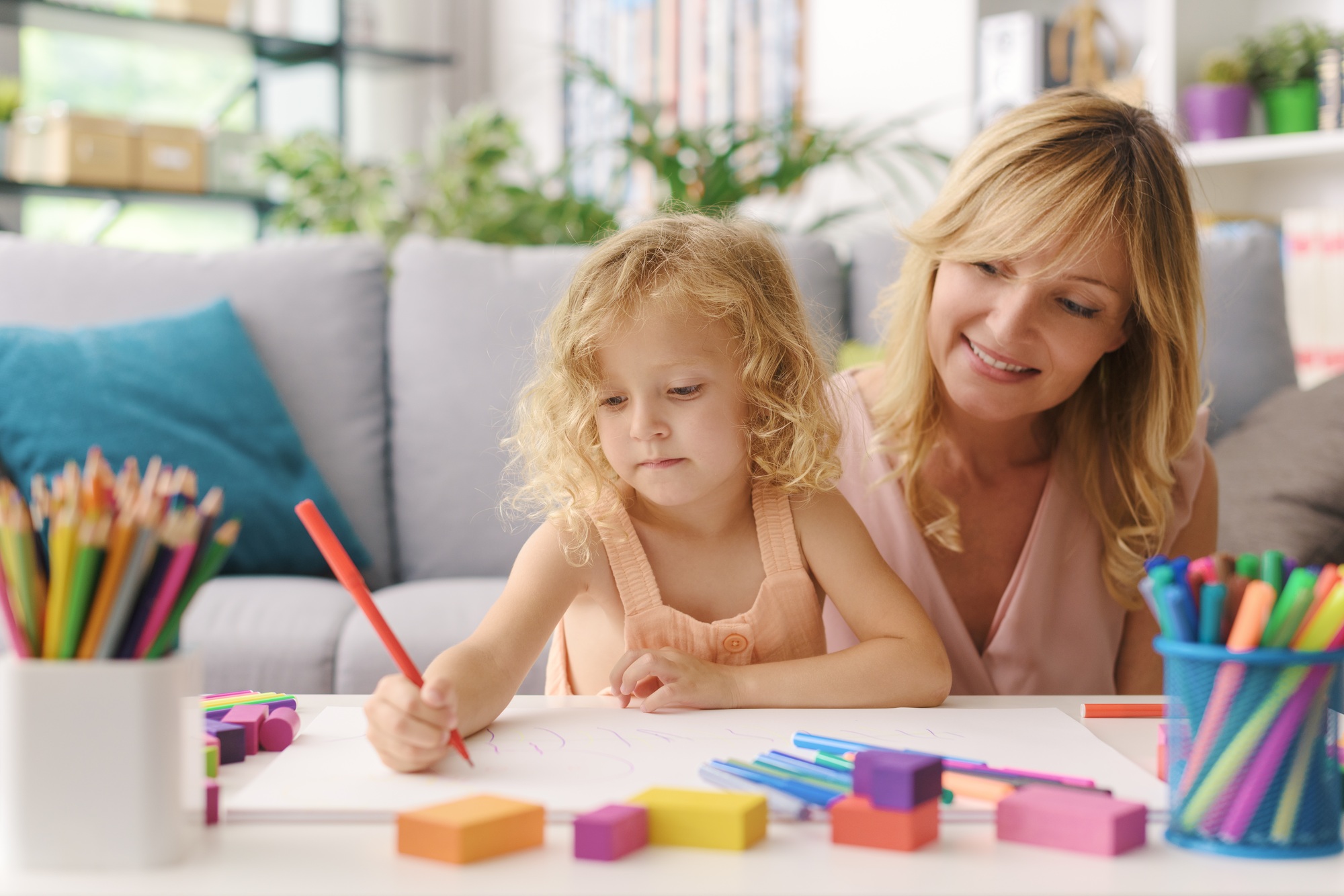Girl and mother drawing together at home