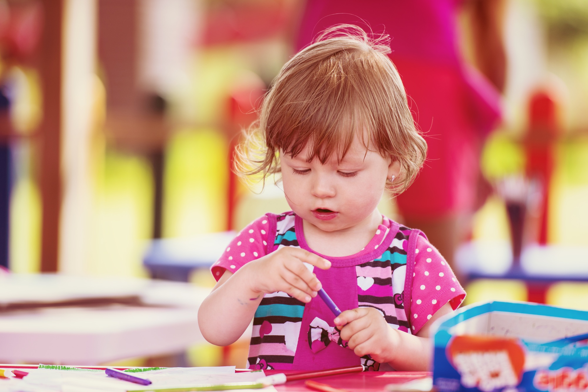 little girl drawing a colorful pictures