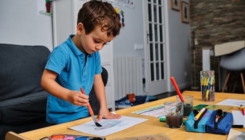 young kid playing with colors and drawing