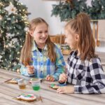 Children draws food paints on Christmas homemade gingerbread cookies. Christmas concept