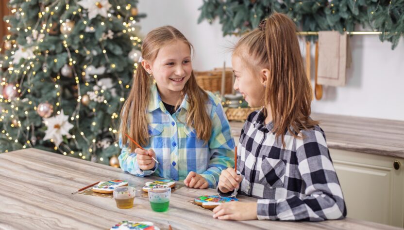 Children draws food paints on Christmas homemade gingerbread cookies. Christmas concept