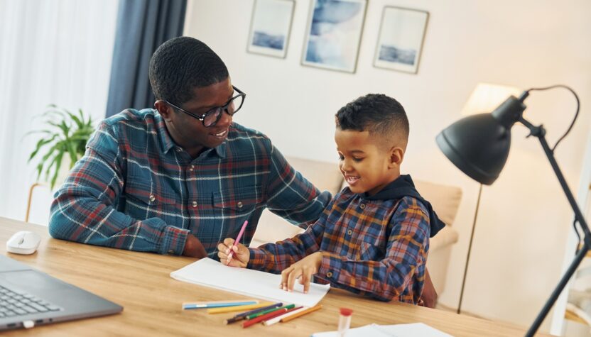 Drawing together. African american father with his young son at home