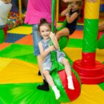 Girl rides on a carousel in a children's play center