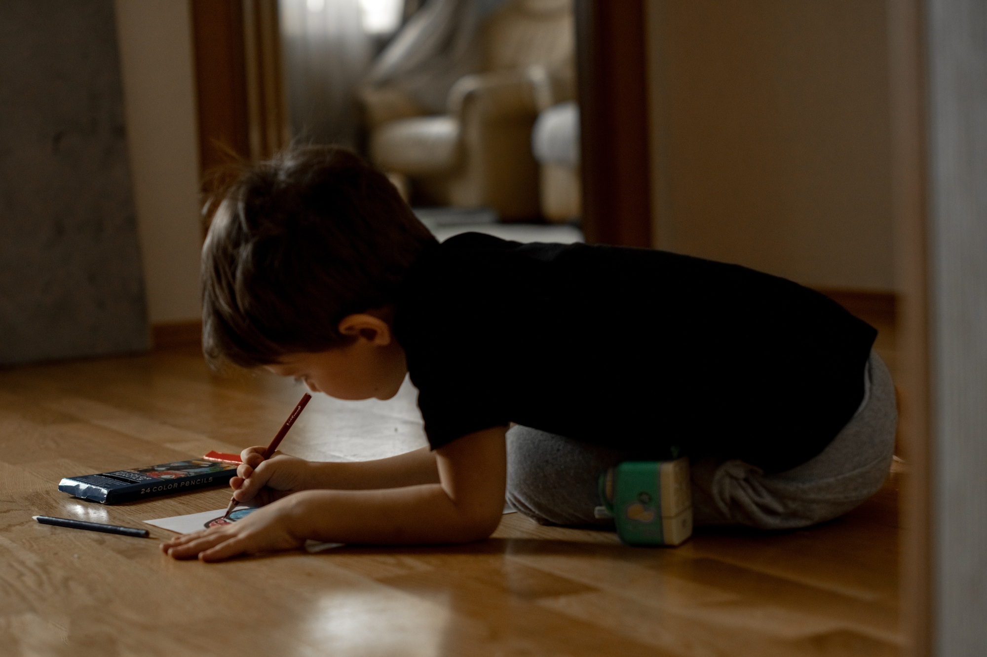 A little boy 5 years old draws a drawing with colored pencils