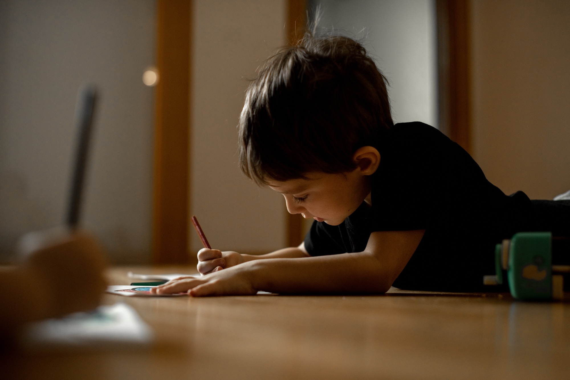 A little boy draws a drawing with colored pencils