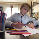 Boy, 9 years old drawing with color pencils