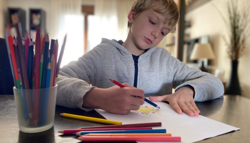Boy, 9 years old drawing with color pencils