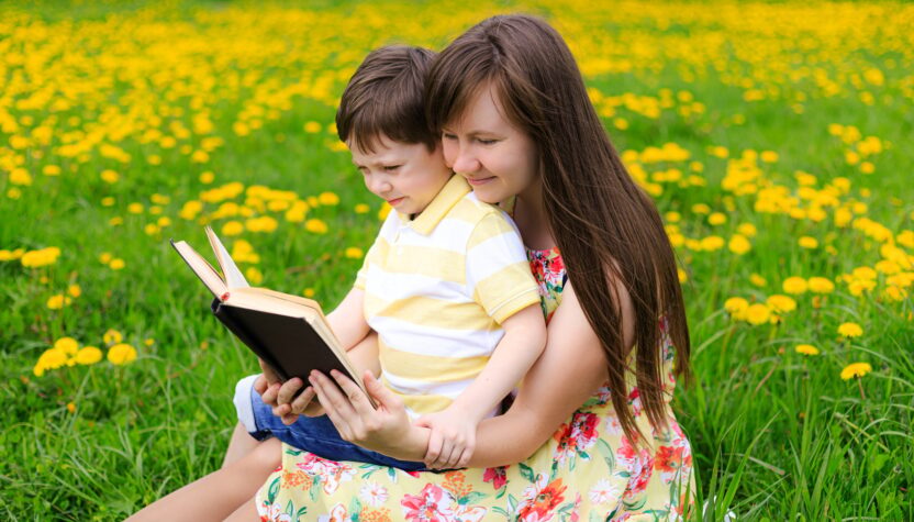 Mother and son reading a book in nature