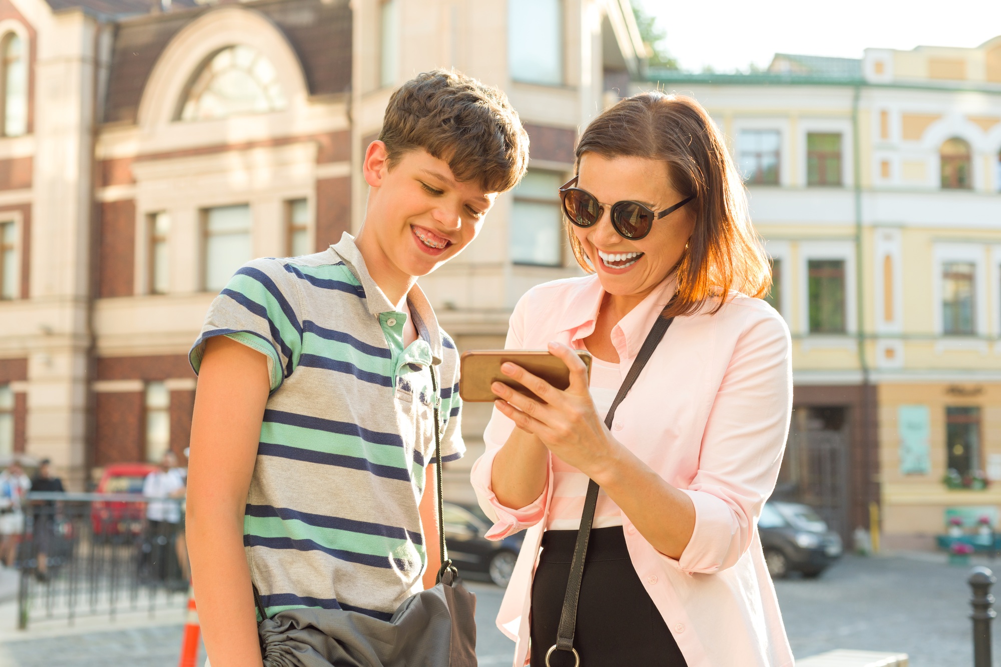Mother and son teenage are looking at the mobile phone