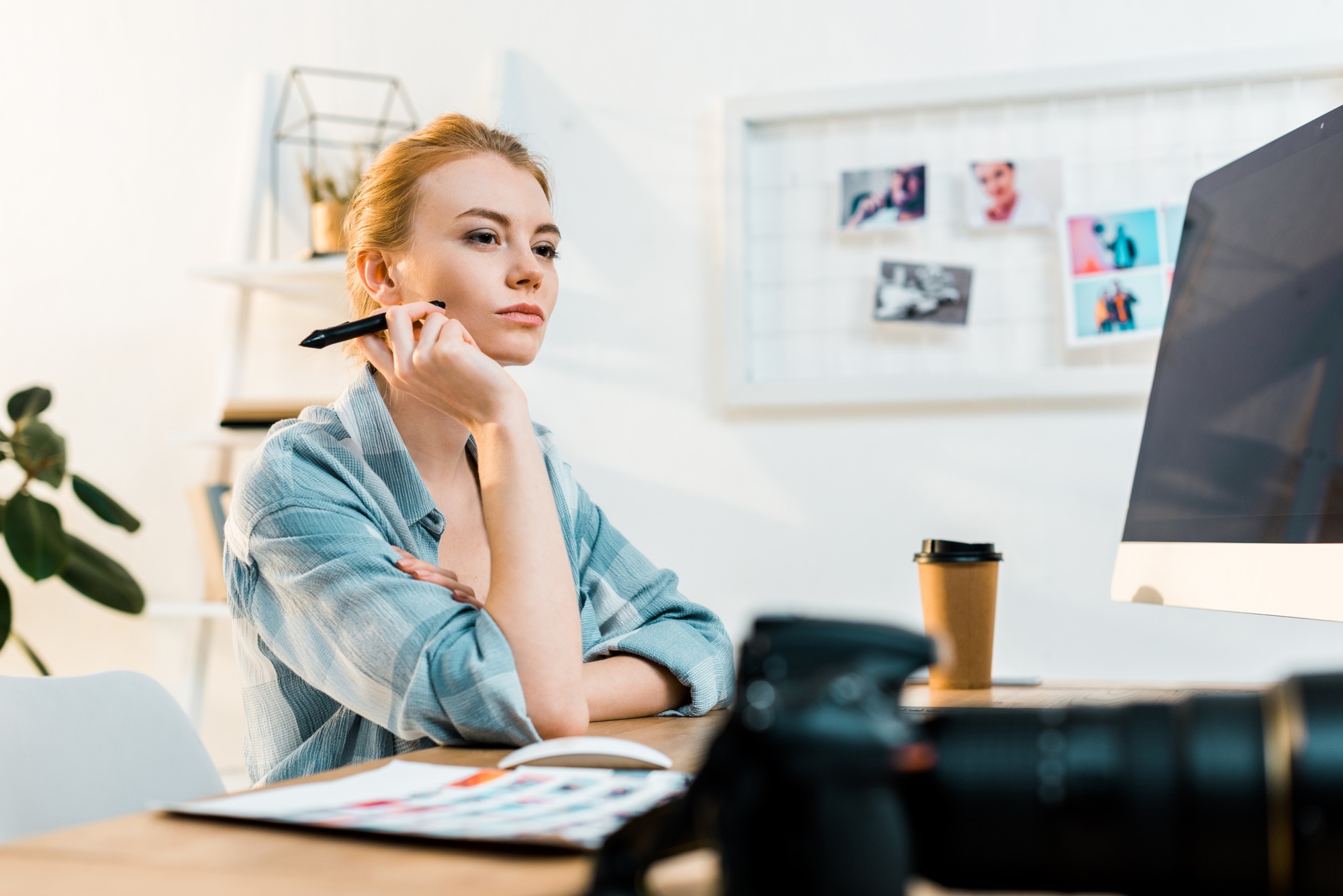 pensive young retoucher using desktop computer and drawing tablet in office