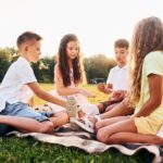 Playing games. Group of happy kids is outdoors on the sportive field at daytime